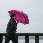 Una mujer se refugia de la lluvia con paraguas 