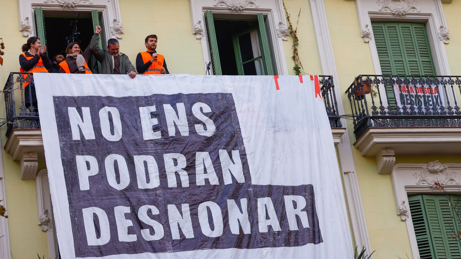 GRAFCAT3383. BARCELONA (ESPAÑA), 31/01/2025.- La comitiva judicial ha aplazado hasta la madrugada del martes el desahucio de Josep Torrent (en la imagen saluda desde el balcón), que se tenía que ejecutar este viernes en la Casa Orsola, un edificio del Eixample de Barcelona que ha comprado un fondo de inversiones para hacer alquileres de temporada y ante el que se han concentrado centenares de personas.El Tribunal Superior de Justicia de Cataluña (TSJC) ha informado de que la comitiva judicial...