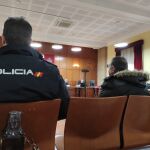 El acusado durante el juicio custodiado por agentes del CNP