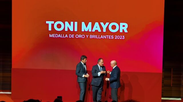 El presidente de la Cámara de Comercio, Carlos Baño, y el presidente de la Generalitat Valenciana, Carlos Mazón, entregan la medalla de oro y brillantes al expresidente de Hosbec, Toni Mayor, en la Noche de la Solidaridad alicantina