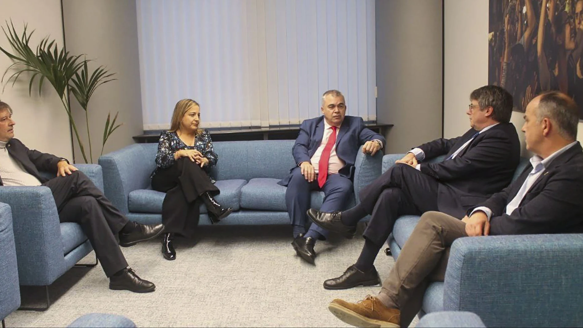 El expresidente de la Generalitat y eurodiputado de JxCat, Carles Puigdemont (2d), y el secretario de organización del PSOE, Santos Cerdán (c), reunidos en la sede del Parlamento Europeo en Bruselas