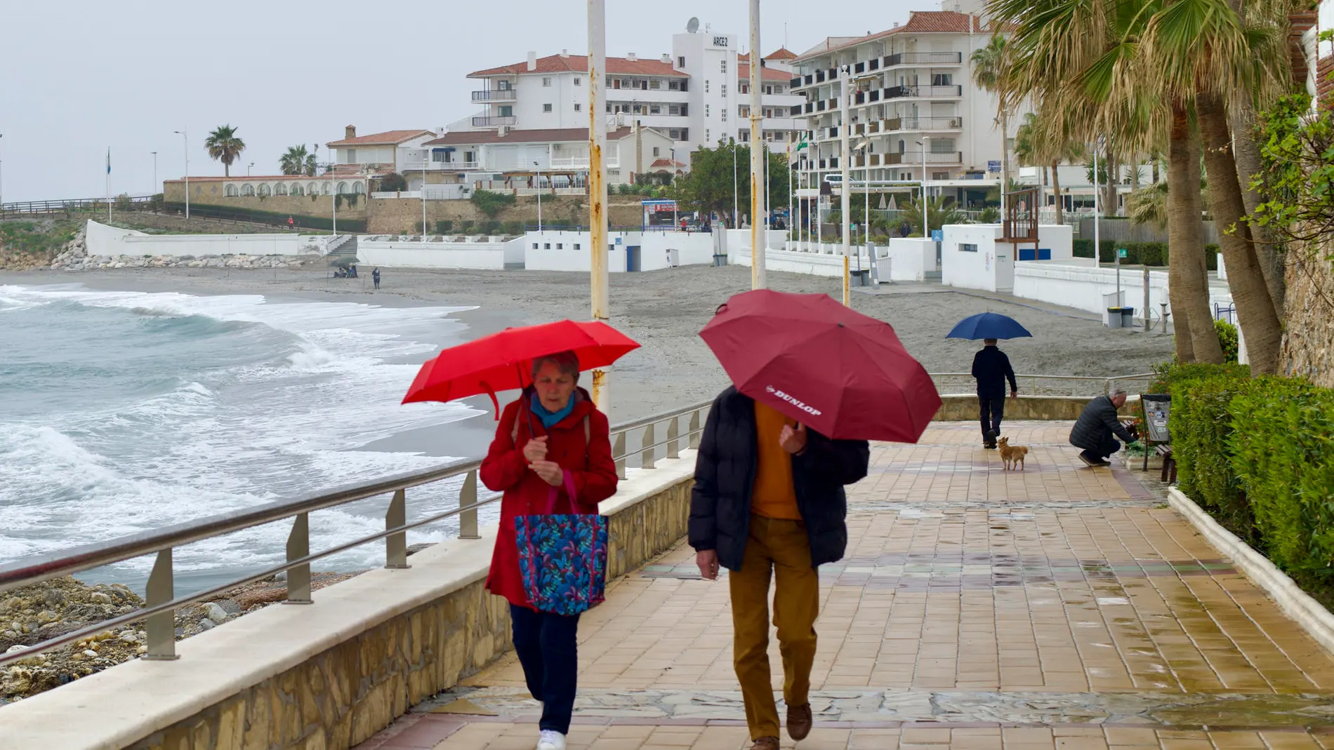 Una pareja camina por el paseo marítimo de la playa de la Torrecilla en Nerja