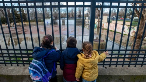 Las intensas lluvias provocan el desbordamiento del río Adaja a su paso por Ávila. En la foto, algunos niños del colegio Juan de Yepes observan el patio de su colegio