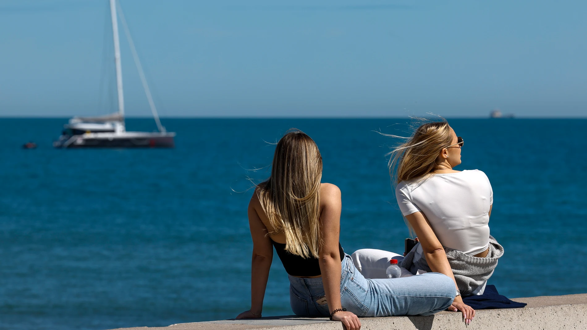 Dos mujeres disfrutan del buen tiempo en la playa de la Malvarrosa