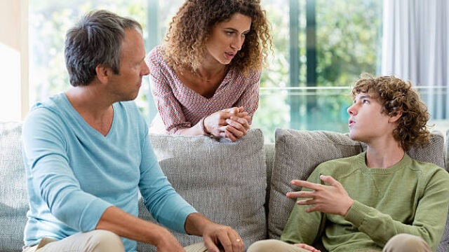 Padres e hijo adolescente teniendo una conversación