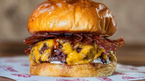 Lleva pan semi brioche, carne gallega, barbacoa, cebolla caramelizada, bacon y queso cheddar