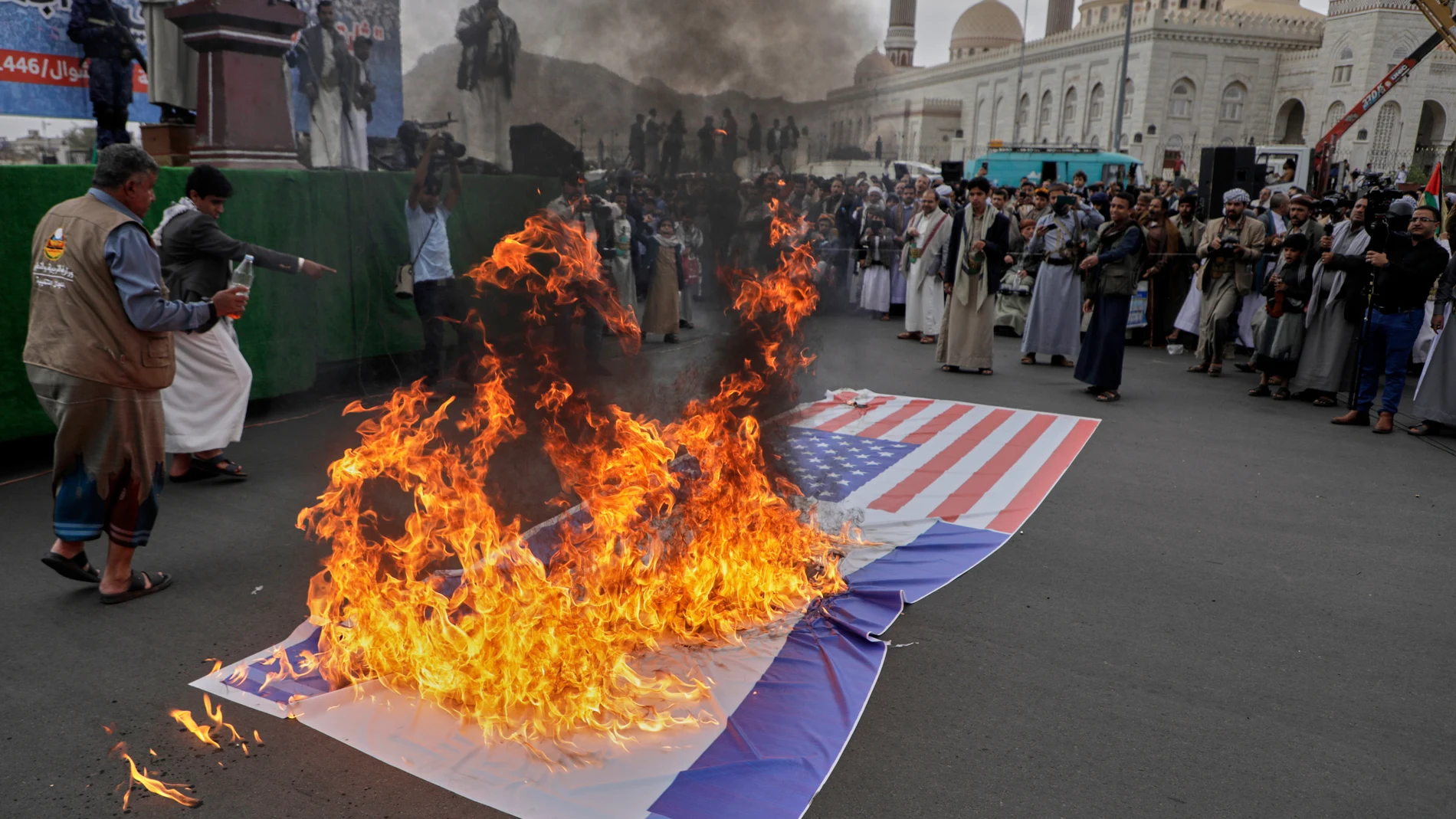 Houthi supporters burn an American and and an Israeli flags during a rally in Sanaa, Yemen, Friday, April 18, 2025. (AP Photo/Osamah Abdulrahman)