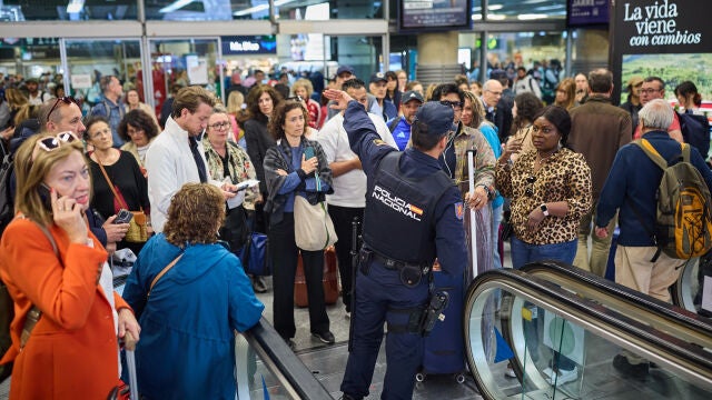 Un agente de Policía, orientandoa pasajeros en Atocha