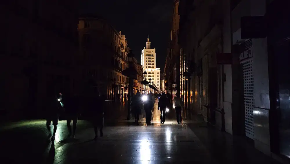Vista de la céntrica calle Larios de Málaga, una de las más reconocidas de España, a oscuras durante la noche del lunes durante el apagón eléctrico