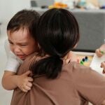 Niño llorando abrazando a su madre
