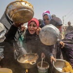 Displaced Palestinians collect donated food in Jabalia, northern Gaza