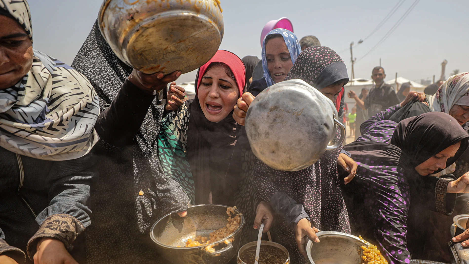 Jabalia (-), 09/05/2025.- Internally displaced Palestinians gather to receive a portion of food from a charity kitchen, in Jabalia refugee camp, northern Gaza Strip, 09 May 2025. According to the UN Palestinian refugee agency UNRWA, over a million people across the Gaza Strip are experiencing 'high levels' of acute food insecurity, with acute malnutrition several times higher than before the war. The UN estimates at least 1.9 million people (nine in ten) are internally displaced. EFE/EPA/MOHA...