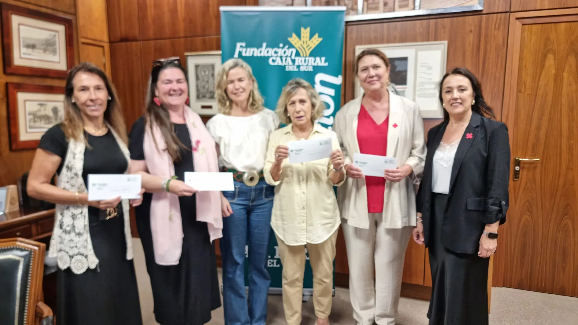 Las epresentantes de las entidades posan con las donaciones
