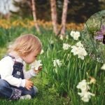 Una niña pequeña junto a unas flores