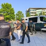 El acusado, conducido por los agentes. 