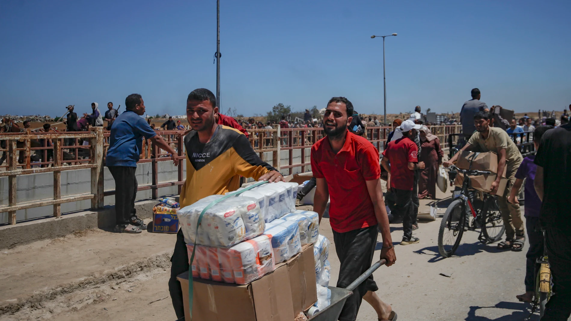 Netzarim Corridor (-), 29/05/2025.- Palestinians carry aid supplies received from the US-backed Gaza Humanitarian Foundation through an area known as the Netzarim Corridor, central Gaza Strip, 29 May 2025. According to the UN half a million people, or one in five people in the Strip are facing starvation while the entire population of the Gaza Strip continues to face a critical risk of famine following 19 months of conflict, mass displacement and severe restrictions on humanitarian aid. EFE/E...