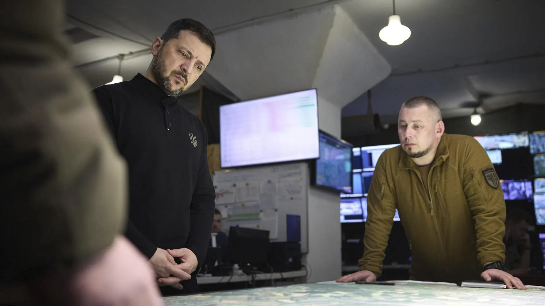 El presidente ucraniano, Volodimir Zelenski, estudia un mapa con los mandos militares