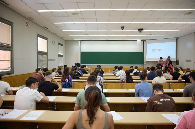 Imagen de un aula con estudiantes examinándose