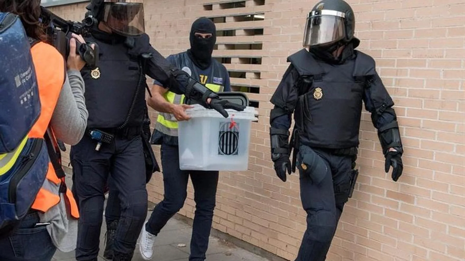 Agentes de policía salen de un registro en vivienda