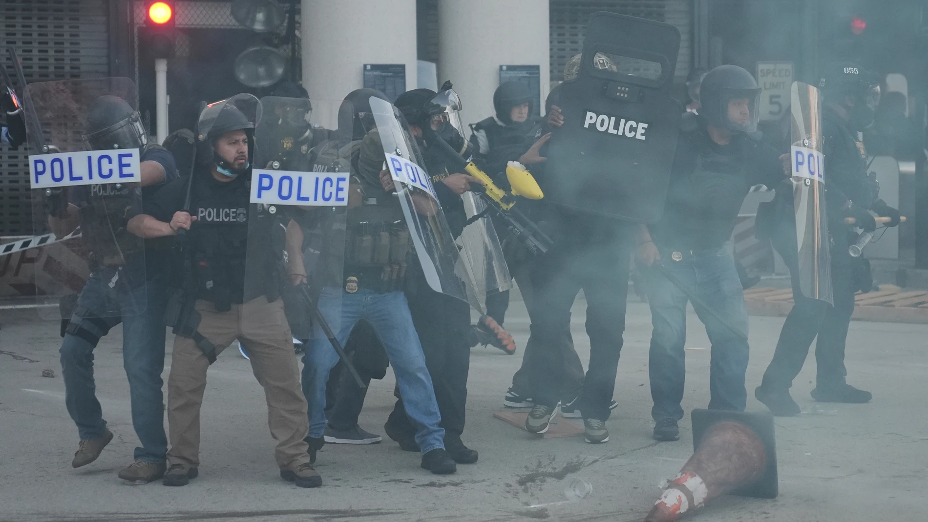 Law enforcement officers gather as tear gas fills the air during a protest after federal immigration authorities conducted an operation on Friday, June 6, 2025, in Los Angeles. (AP Photo/Jae C. Hong)