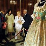 Varias personas fotografían y contemplan el traje confeccionado por el indumentarista Enrique Marzal como regalo de boda para la entonces prometida del Príncipe Felipe, Letizia Ortiz