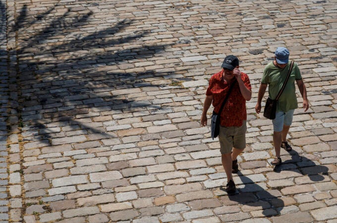 Unos turistas caminando por el paseo fluvial del Guadalquivir de Sevilla