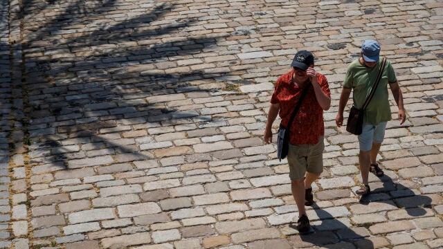 Unos turistas caminando por el paseo fluvial del Guadalquivir de Sevilla