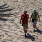 Unos turistas caminando por el paseo fluvial del Guadalquivir de Sevilla
