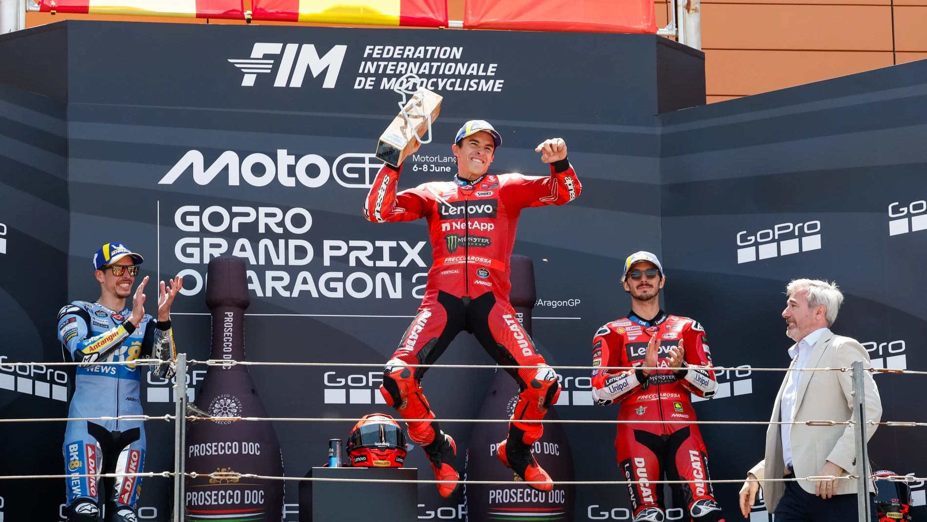ALCAÑIZ (TERUEL), 08/06/2025.- El piloto Marc Márquez, de Ducati Lenovo Team, primer clasificado, su hermano Álex Márquez (i), segundo, y el italiano Francesco Bagnaia (2d), tercero en el podio tras la carrera de MotoGP del Gran Premio de Aragón en el circuito Motorland de Alcañiz (Teruel), este domingo. En la imagen, el presidente de Aragón, Jorge Azcón (d), tras hacer entrega de los trofeos. EFE/Javier Cebollada