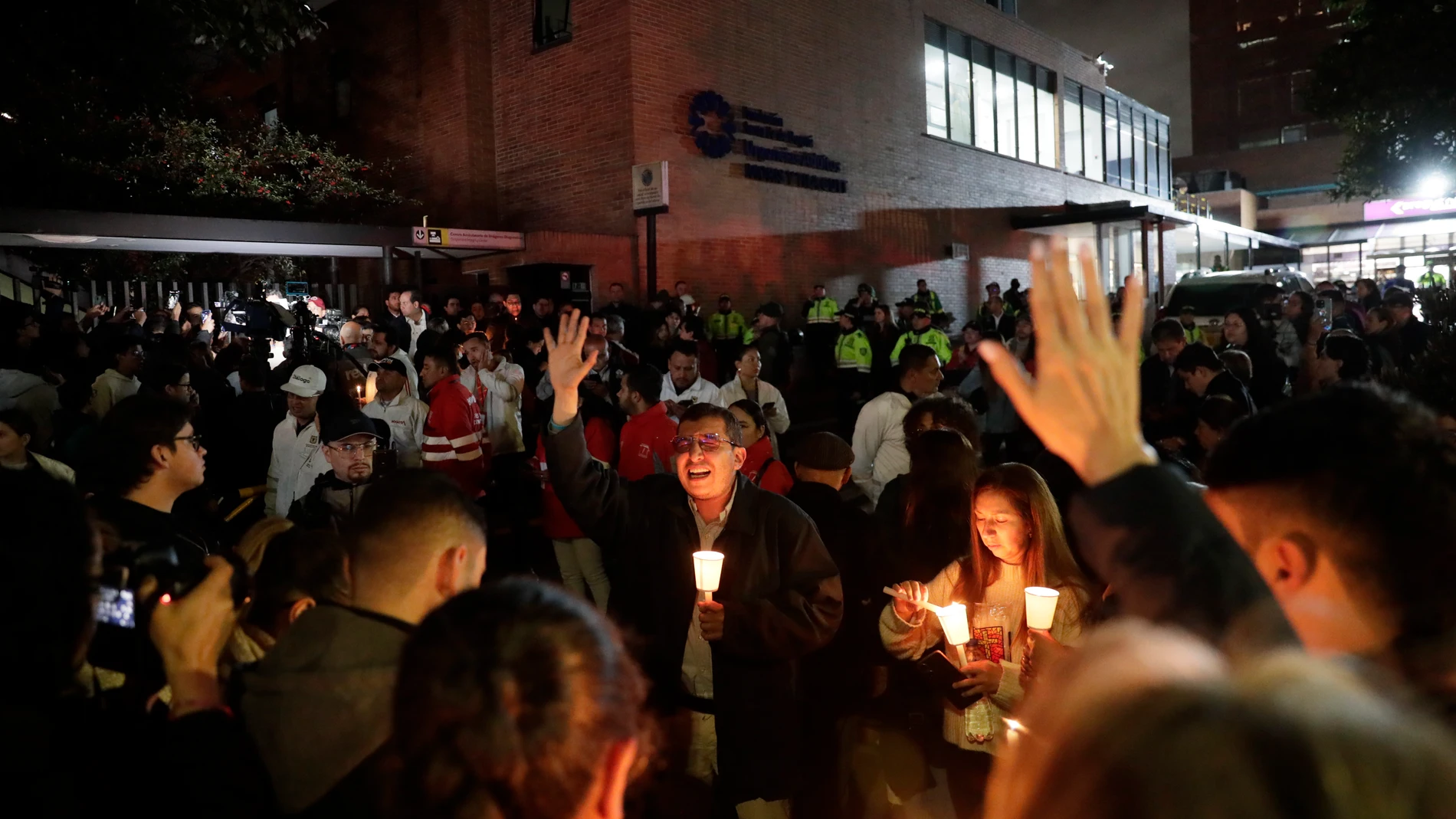 AME4312. BOGOTÁ (COLOMBIA), 07/06/2025.- Personas encienden velas a las afueras de la Fundación Santa Fe donde fue trasladado el senador colombiano Miguel Uribe Turbay este sábado, en Bogotá (Colombia). Uribe Turbay fue trasladado a la Clínica Fundación Santa Fe de Bogotá, una de las instituciones médicas más reconocidas del país, tras ser gravemente herido con varios disparos. EFE/ Carlos Ortega