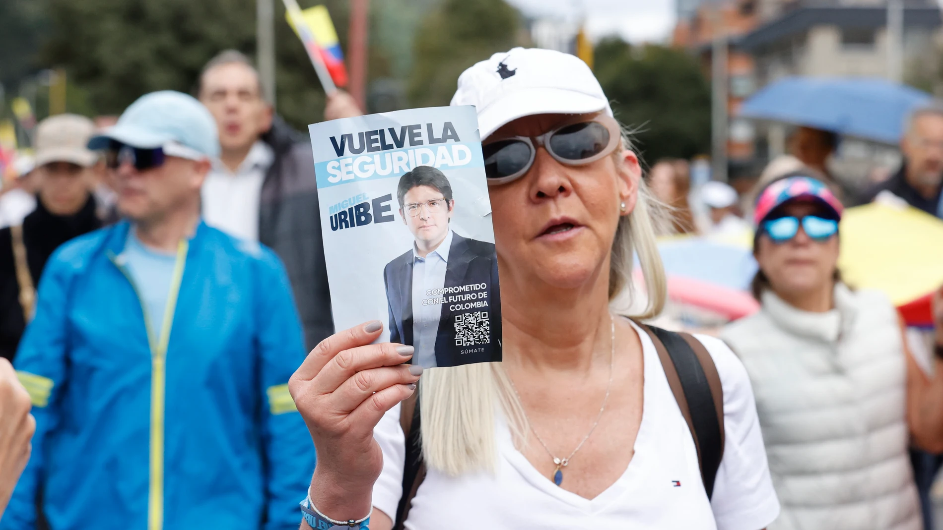 AME4418. BOGOTÁ (COLOMBIA), 08/06/2025.- Una mujer sostiene un cartel durante una caminata por la paz y en apoyo al senador Miguel Uribe Turbay este domingo, en Bogotá (Colombia). La peor expresión de la violencia política colombiana resurgió con el atentado que tiene entre la vida y la muerte al senador y aspirante presidencial de derecha Miguel Uribe Turbay, un ataque que avivó el temor a que el país vuelva a los oscuros años de finales del siglo pasado cuando fueron asesinados varios candi...