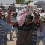 Un palestino carga con un saco de ayuda humanitaria en Gaza