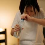 Una persona bebiendo agua en la cama