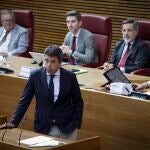 Mazón espera a que los diputados de Compromís se sienten en sus escaños para seguir su intervención