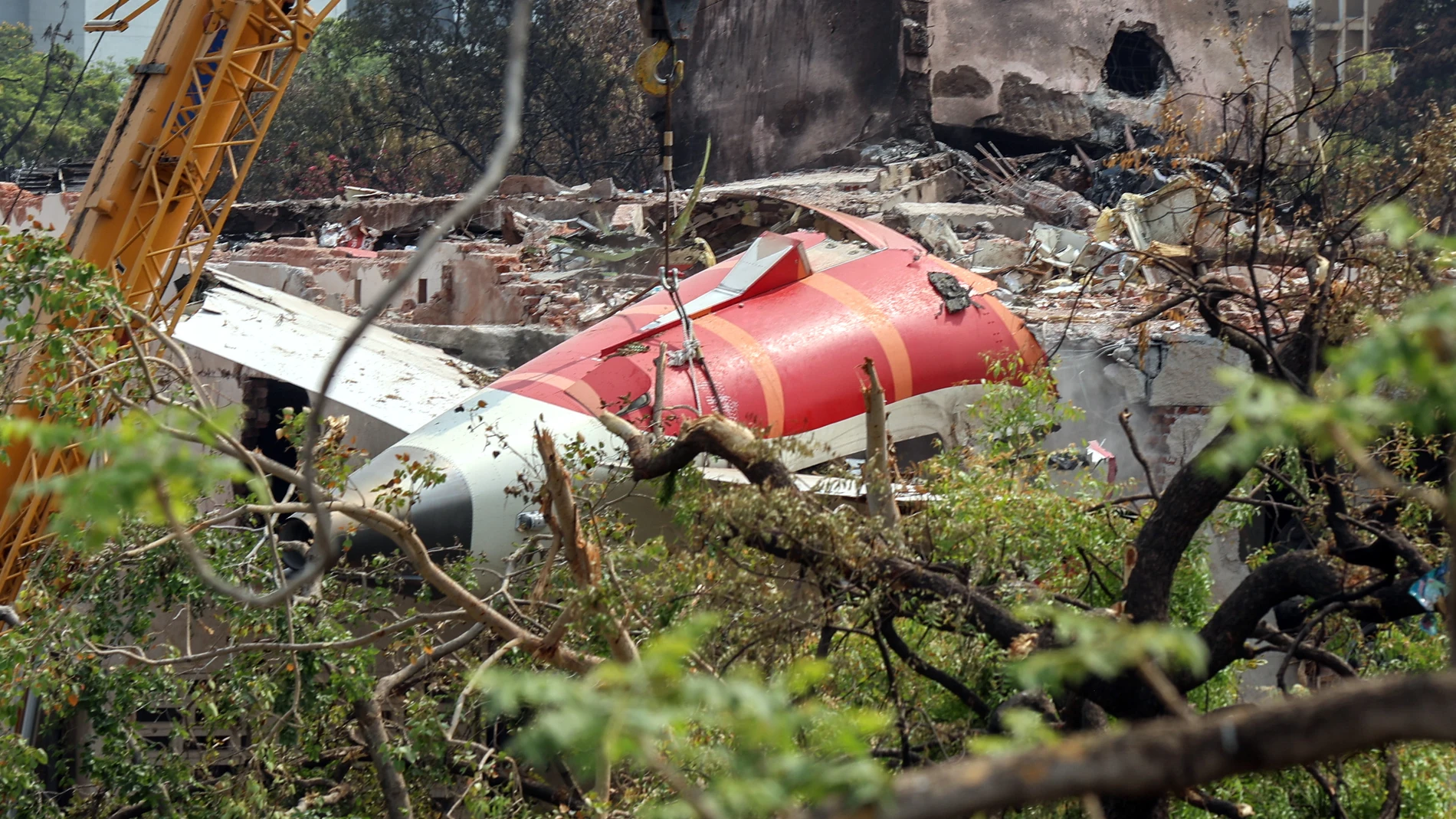 AHMEDABAD (India), 14/06/2025.- A crawler crane is used to remove the wreckage of the Air India passenger plane from the crash site, near Sardar Vallabhbhai Patel International Airport in Ahmedabad, Gujarat state, western India, 14 June 2025. Air India flight AI171, bound for London carrying 242 passengers and crew members on board a Boeing 787-8 aircraft, crashed minutes after take-off in the Meghaninagar area of Ahmedabad on 12 June. (Londres) EFE/EPA/RAJAT GUPTA
