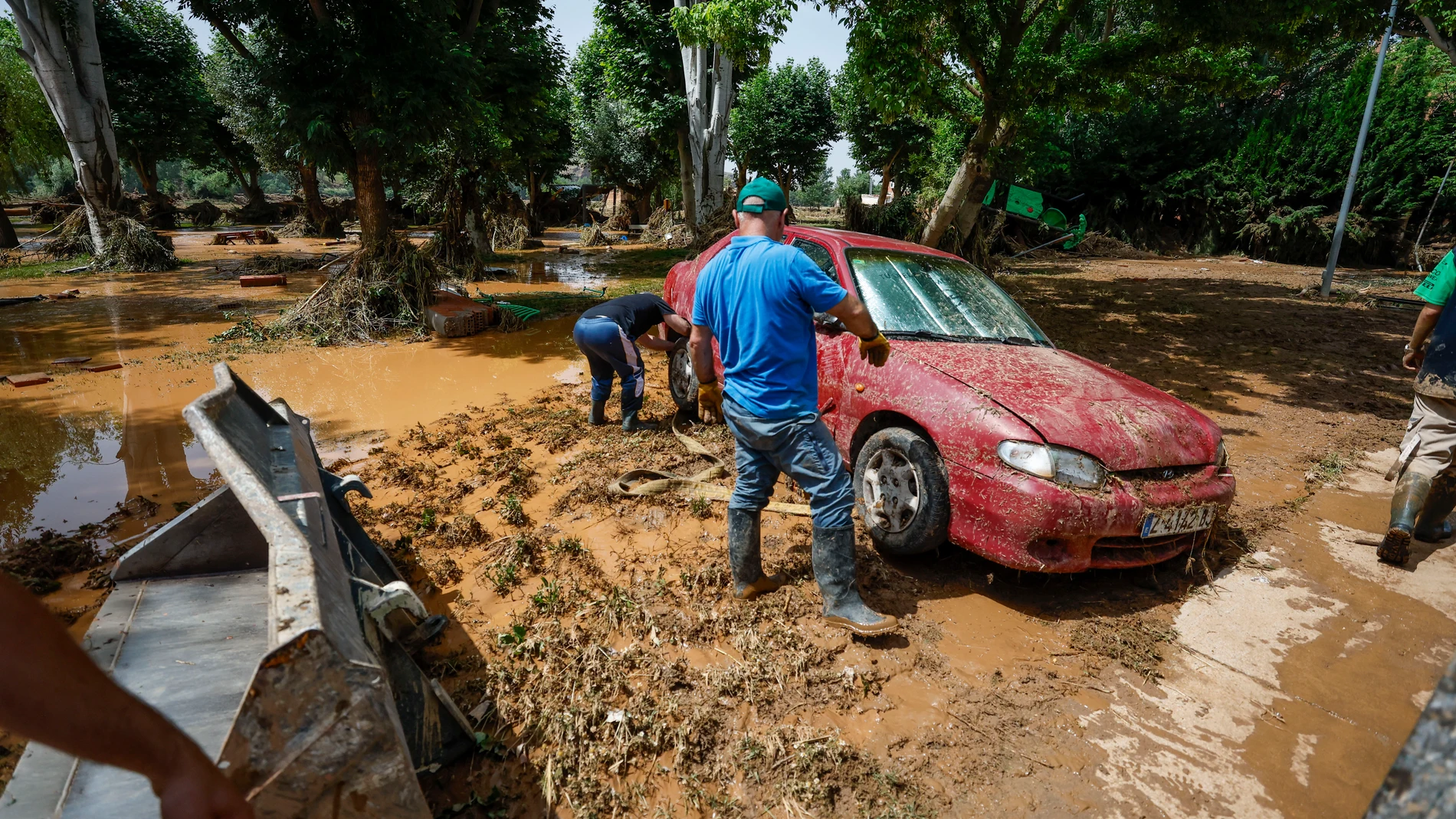 AZUARA (ZARAGOZA), 14/06/2025.- Dos personas junto a un coche afectado por la tormenta, este sábado en la localidad de Azuara (Zaragoza). Cuatro carreteras permanecen cortadas tras las fuertes tormentas que descargaron a última hora de este viernes en zonas de la provincia de Zaragoza y Teruel y que obligaron al rescate de diez vecinos de la localidad de Letux atrapados por el agua. EFE/ Javier Cebollada