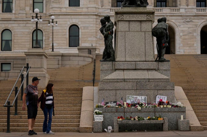 James Harnan, a la izquierda, y Jane Faragher, a la derecha, visitan un monumento improvisado en memoria de la diputada del estado de Minnesota Melissa Hortman y su marido Mark en el Capitolio del estado,
