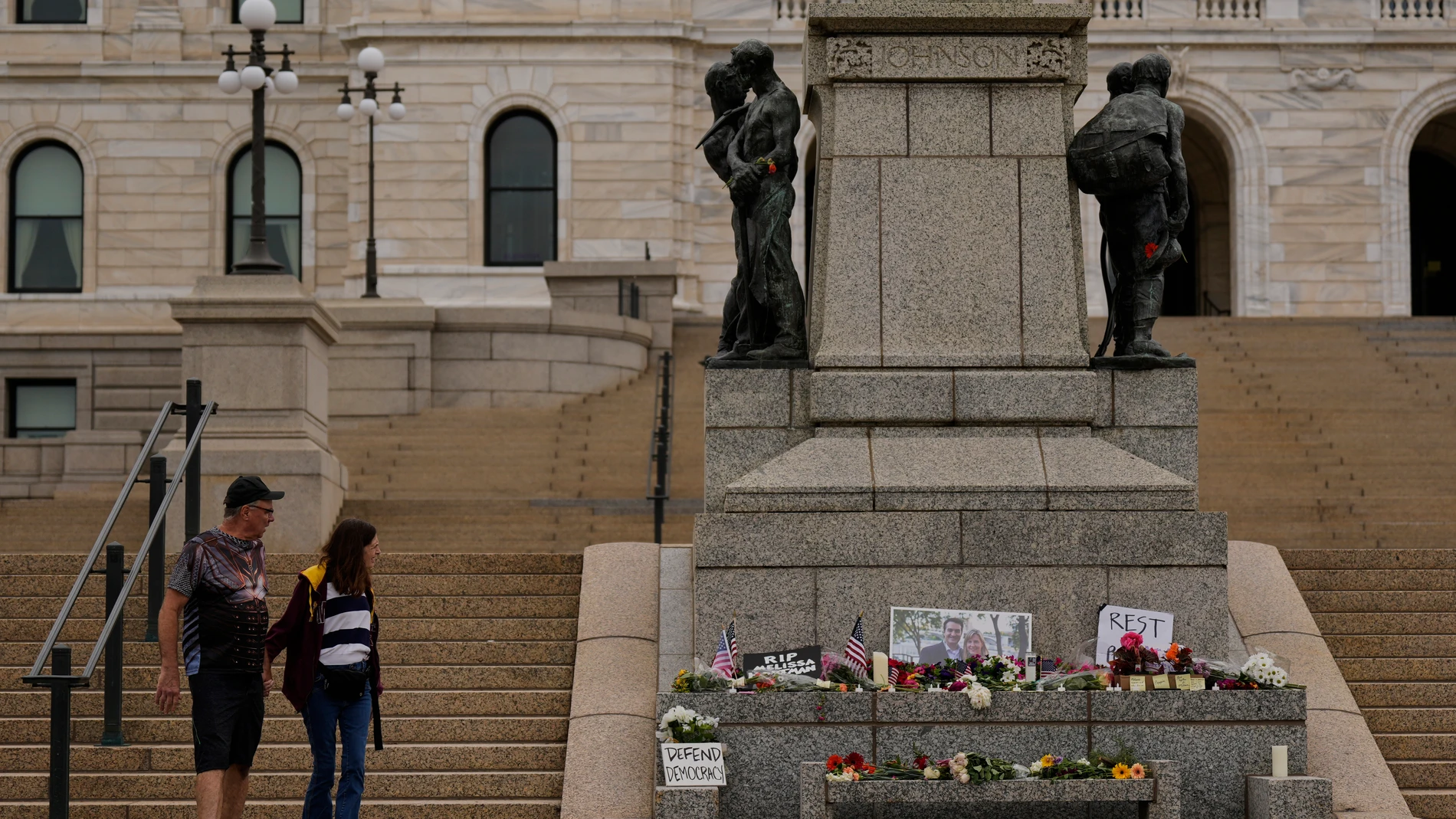 James Harnan, left, and Jane Faragher, right, visit a makeshift memorial for Minnesota state Rep. Melissa Hortman and her husband Mark at the state Capitol, Sunday, June 15, 2025, in St. Paul, Minn. (AP Photo/George Walker IV)