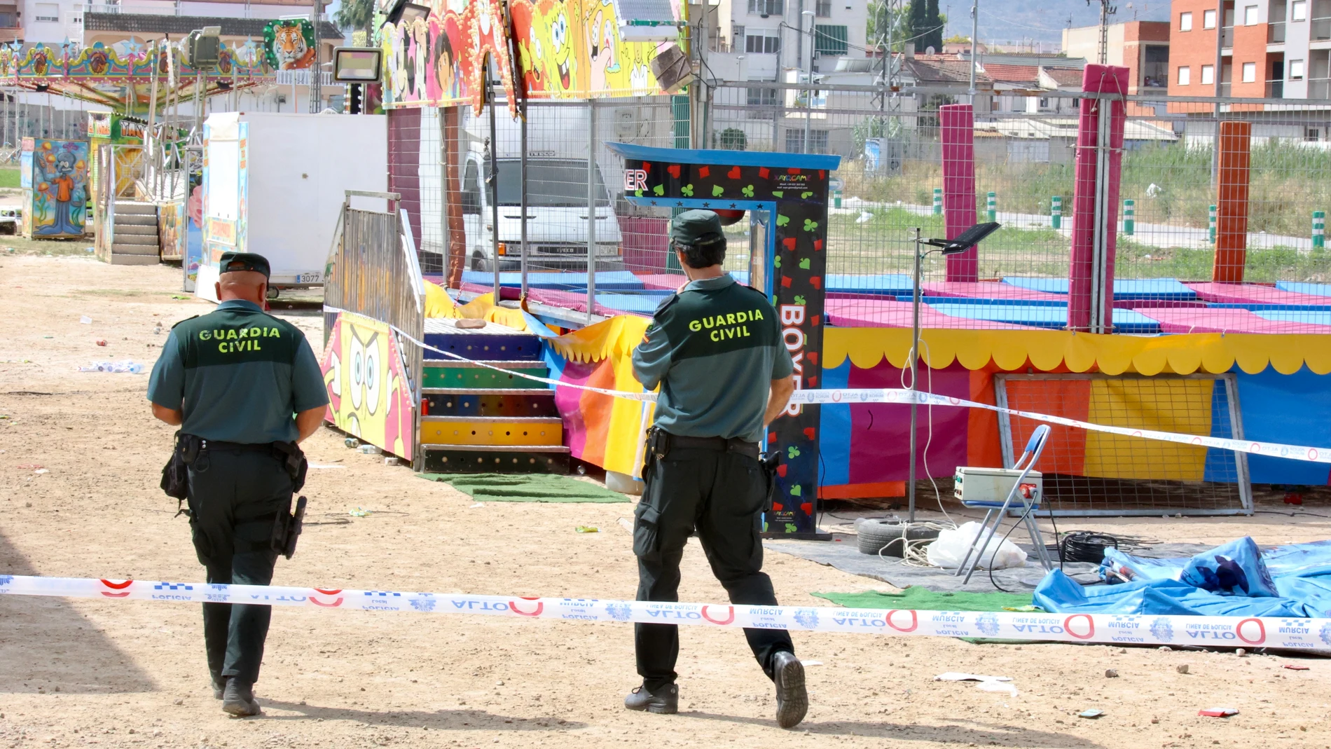 FOTODELDIA ALQUERÍAS (MURCIA), 15/06/2025.- Agentes de la Guardia Civil precintan este domingo las camas elásticas del recinto ferial de la pedanía murciana de Alquerías después de que una niña de dos años falleciera esta madrugada al recibir una descarga eléctrica. EFE/ Juan Carlos Caval