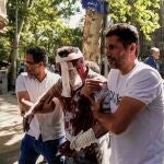 Un hombre herido es ayudado a abandonar el lugar de los hechos tras una explosión en el centro de Teherán, en medio de la campaña de ataques de Israel
