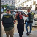 Uno de los detenidos es conducido por agentes de la Guardia Civil