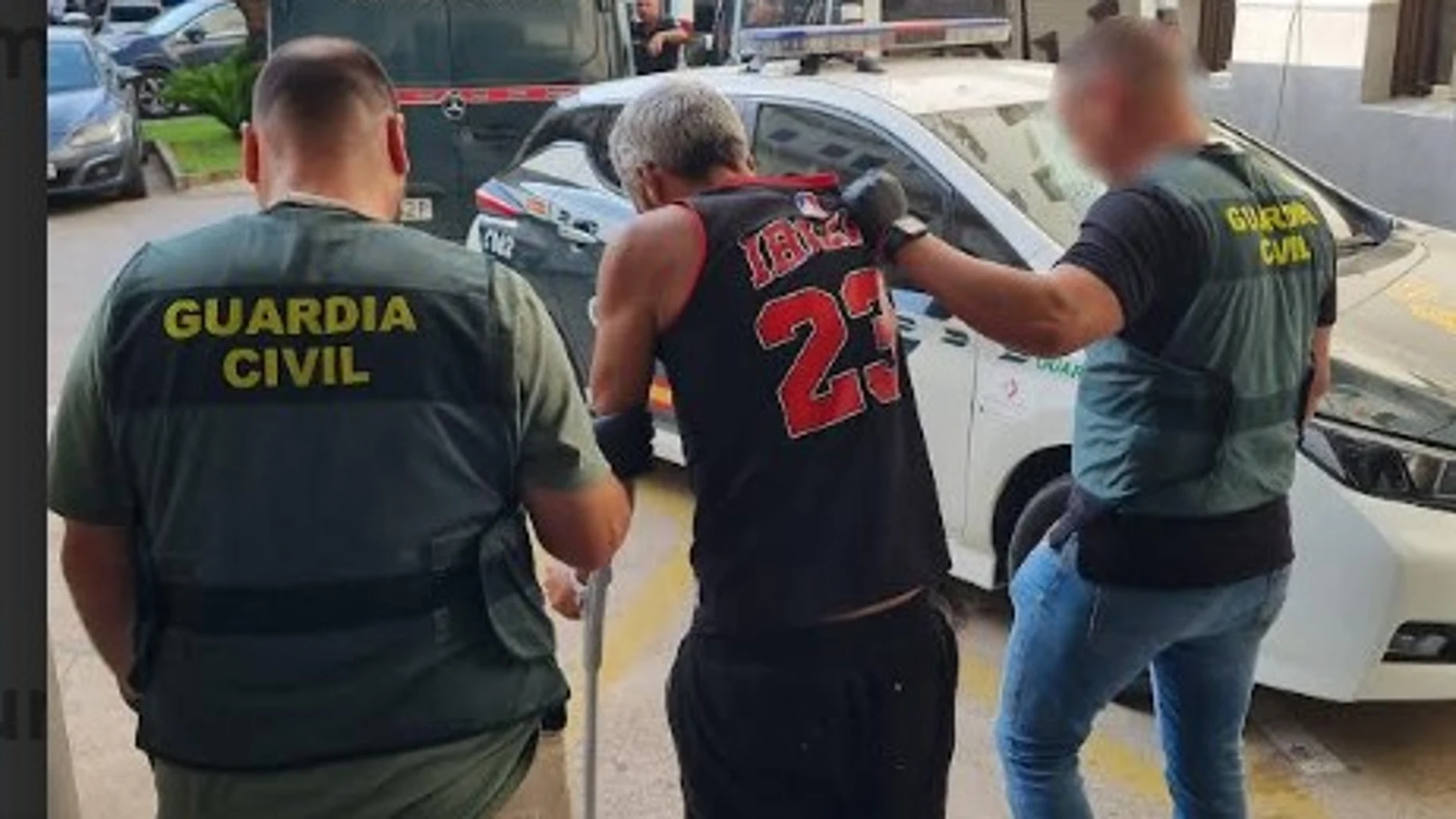 Uno de los detenidos es conducido por agentes de la Guardia Civil