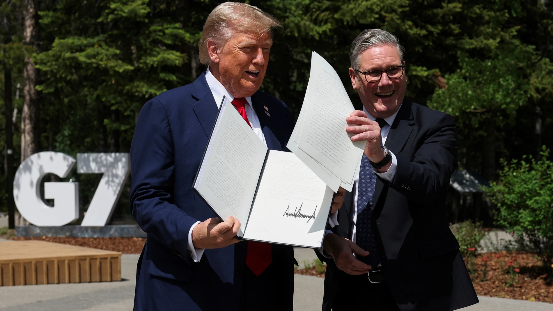 U.S. President Donald Trump, left, and Britain's Prime Minister Keir Starmer hold a signed U.K.-U.S. trade agreement during a meeting at the G7 summit, in Kananaskis, Alberta, Monday, June 16, 2025. (/Suzanne Plunkett/Pool Photo via AP)