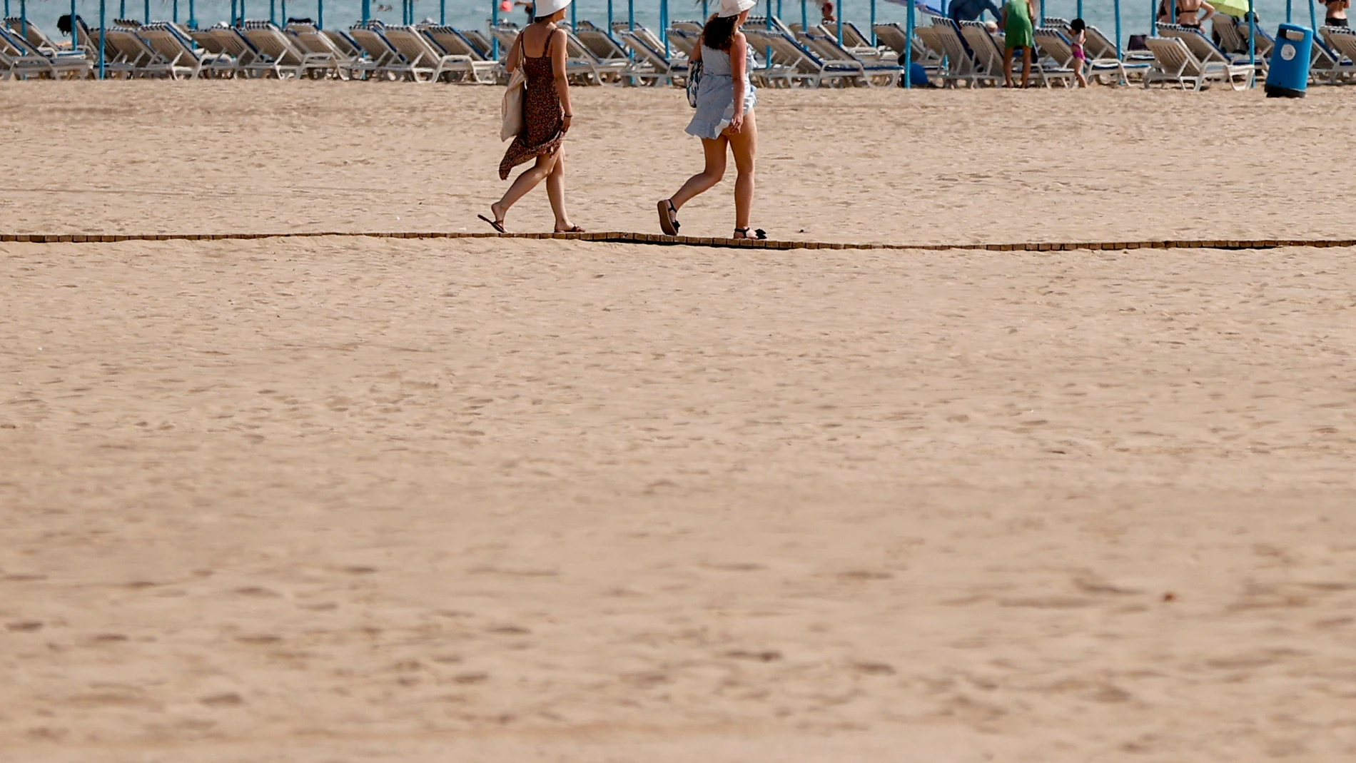 GRAFCVA8189. VALENCIA, 17/06/2025.- Dos personas pasean por la playa de la Malvarrosa durante la mañana de este martes en el que toda la península, salvo la franja norte y buena parte del litoral -diez comunidades en concreto- están en aviso por calor, lluvias y tormentas con posibilidad de fuerte viento y granizo, y de ellas cinco se encuentran en nivel de riesgo naranja (importante), con temperaturas de hasta 41 grados en Andalucía. EFE/Manuel Bruque