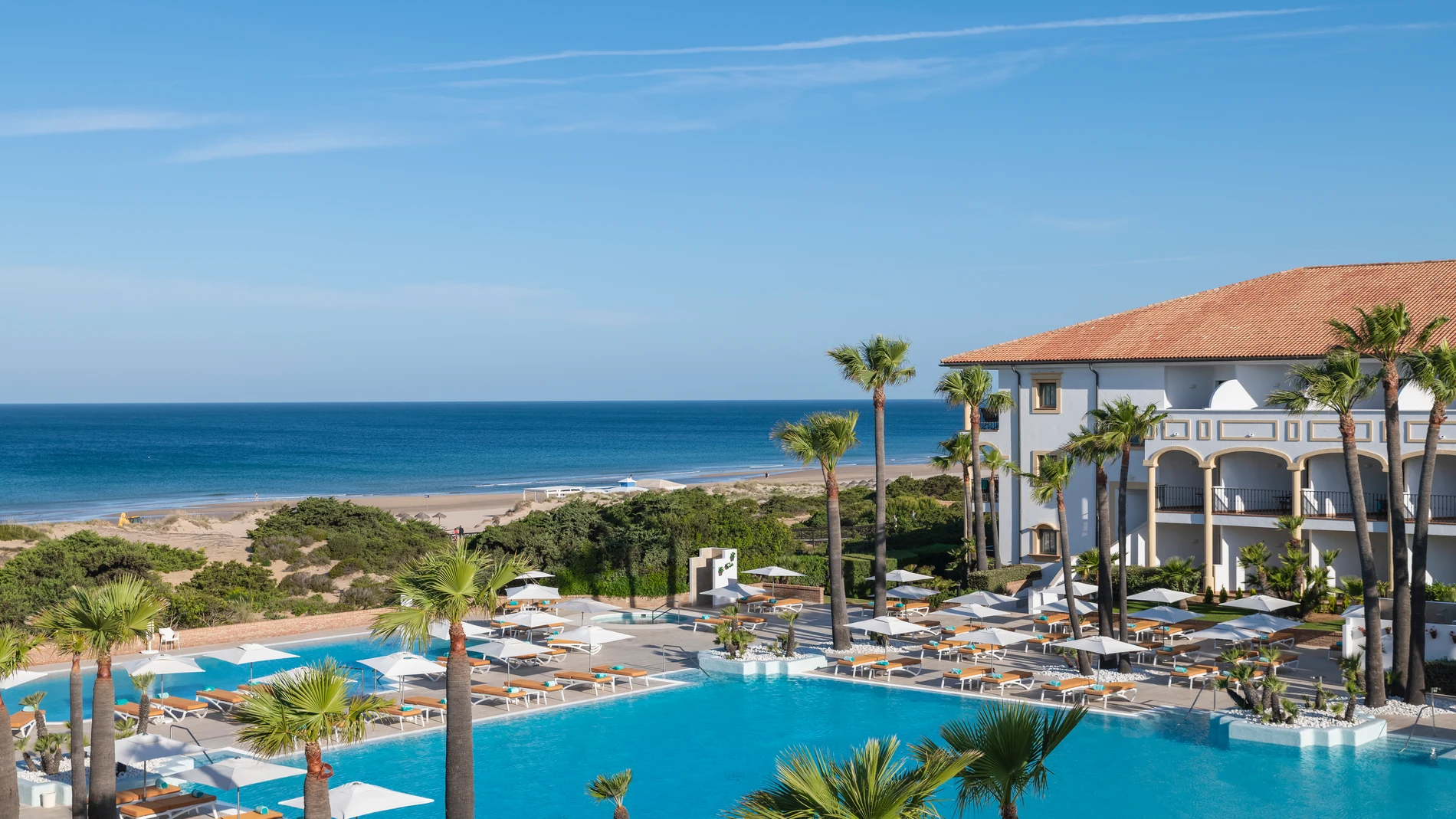 Vista de las impresionantes piscinas exteriores del hotel con el Atlántico como telón de fondo