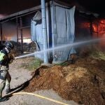 MURCIA.-Sucesos.- Bomberos trabajan en las labores de extinción de un incendio en un almacén de balas de paja de Campos del Río