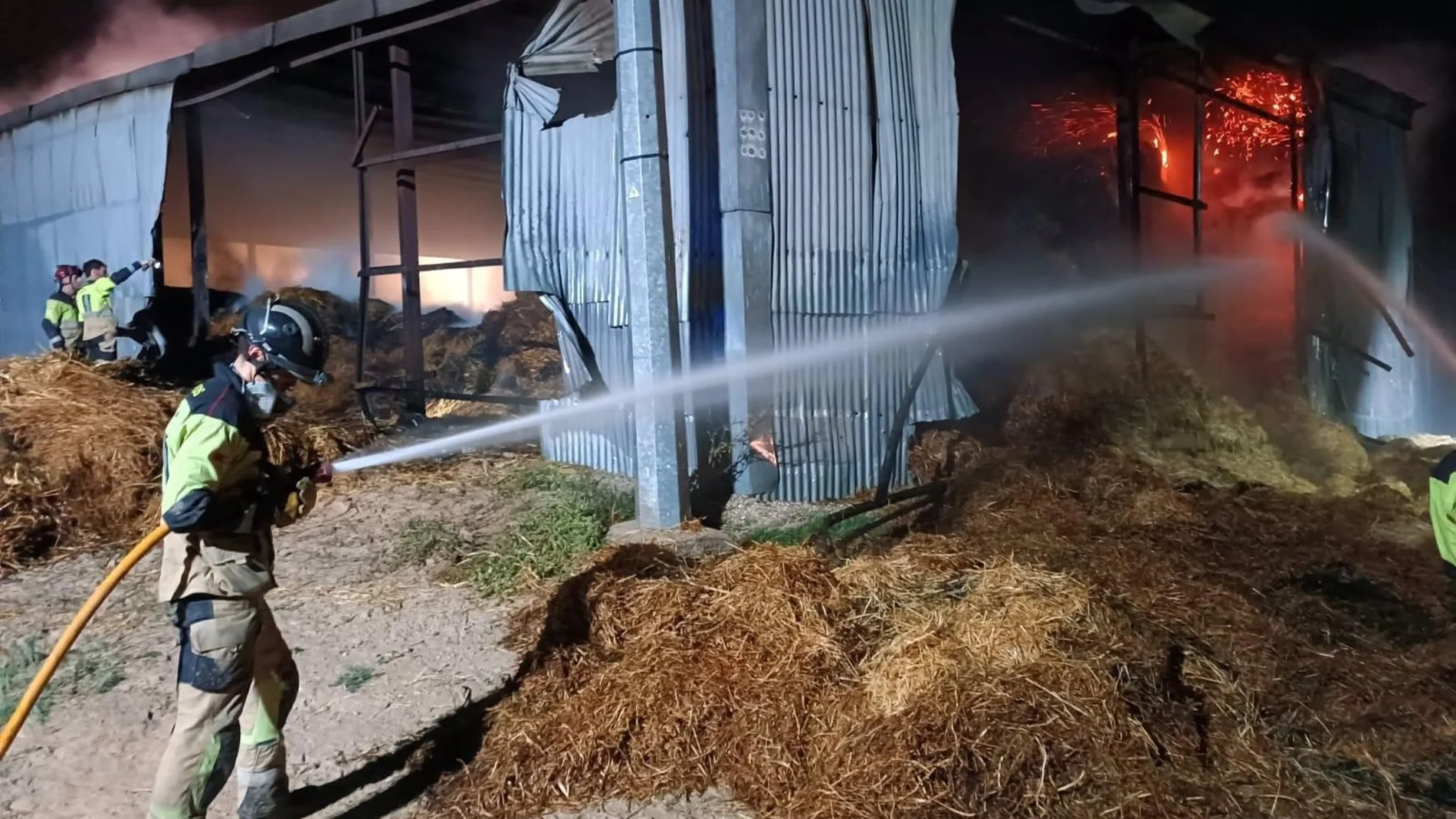 MURCIA.-Sucesos.- Bomberos trabajan en las labores de extinción de un incendio en un almacén de balas de paja de Campos del Río