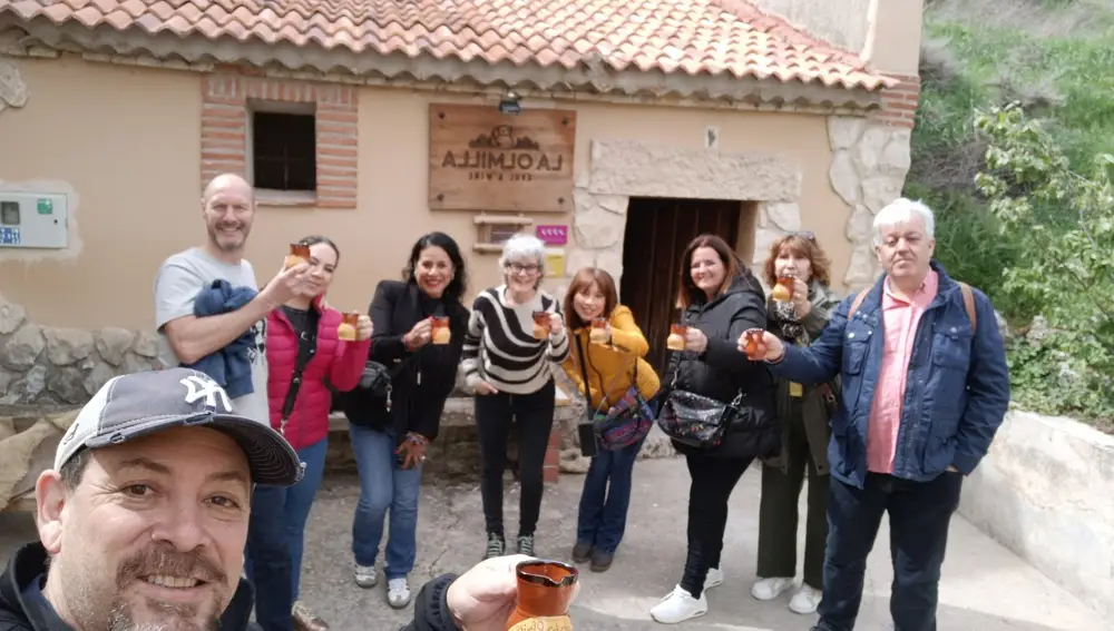 Gruo de visitantes brinda con el jarrillo típico de vino de la zona junto a Silvia Camacho a las puertas de La Olmilla