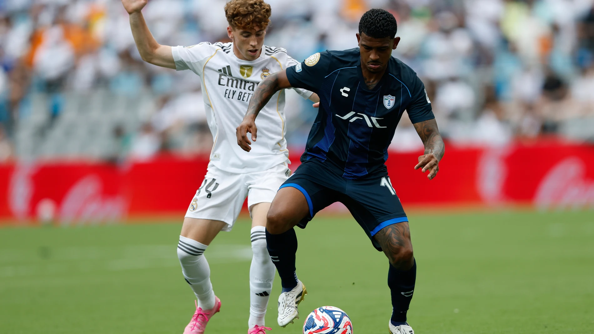 Real Madrid's Victor Munoz, left, and Pachuca's John Kennedy fight for the ball during the Club World Cup Group H soccer match between Real Madrid and CF Pachuca in Charlotte, N.C., Sunday, June 22, 2025. (AP Photo/Nell Redmond)
