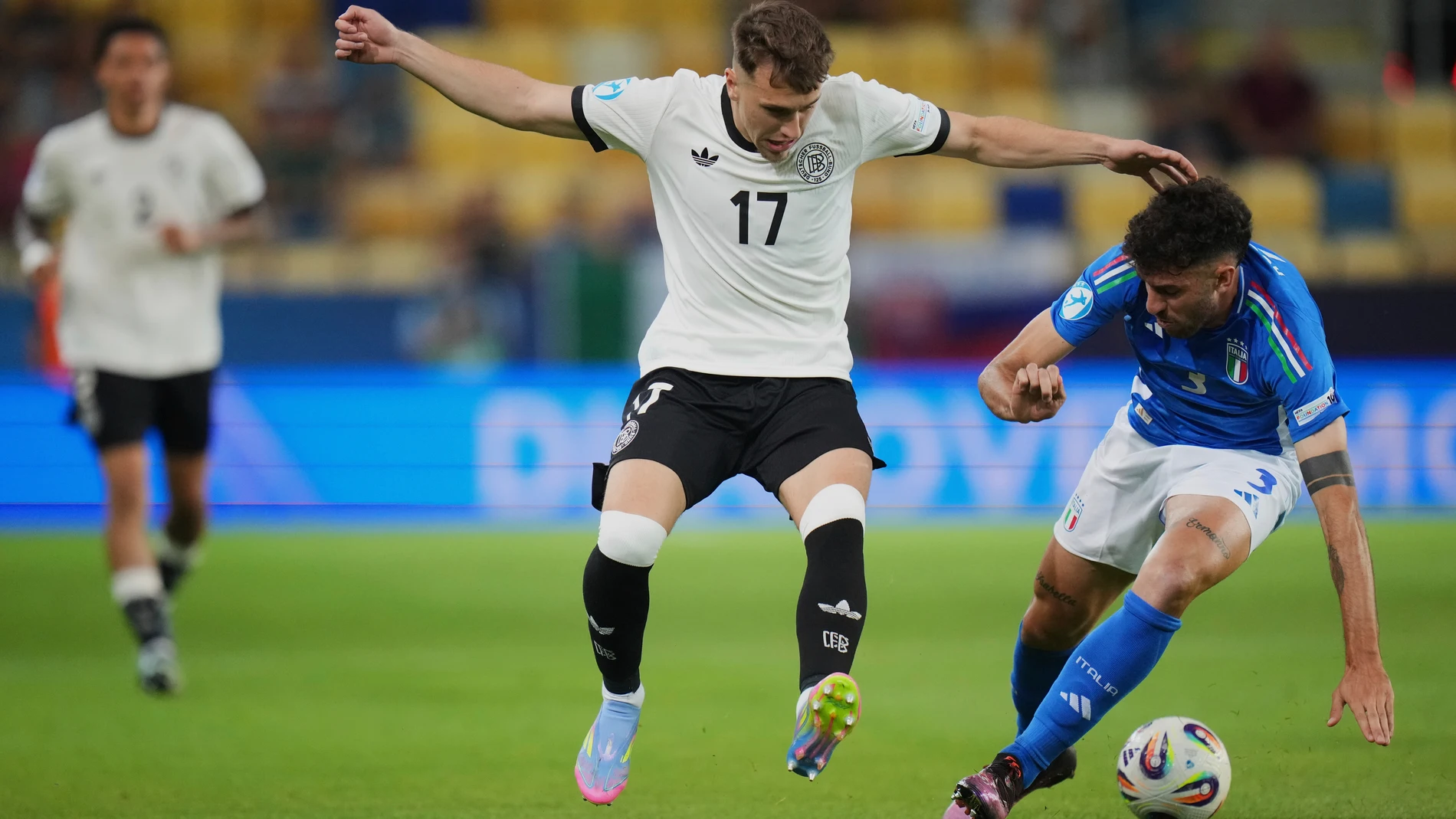 Germany's Brajan Gruda, center, duels for the ball with Italy's Matteo Ruggeri during a quarter final soccer match between Germany and Italy at the European U-21 Championship at the DAC Arena in Dunajska Streda, Slovakia, Sunday, June 22, 2025. (AP Photo/Petr David Josek)